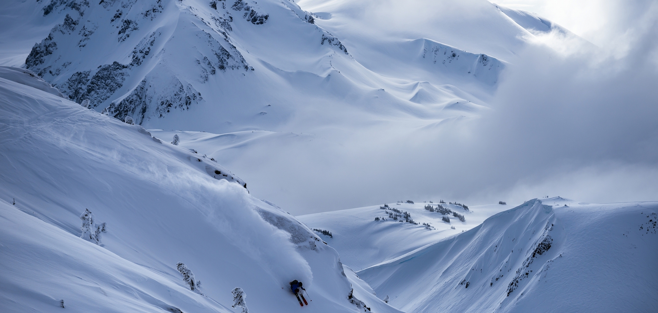 A sprawling mountain range with towering peaks and bowls.