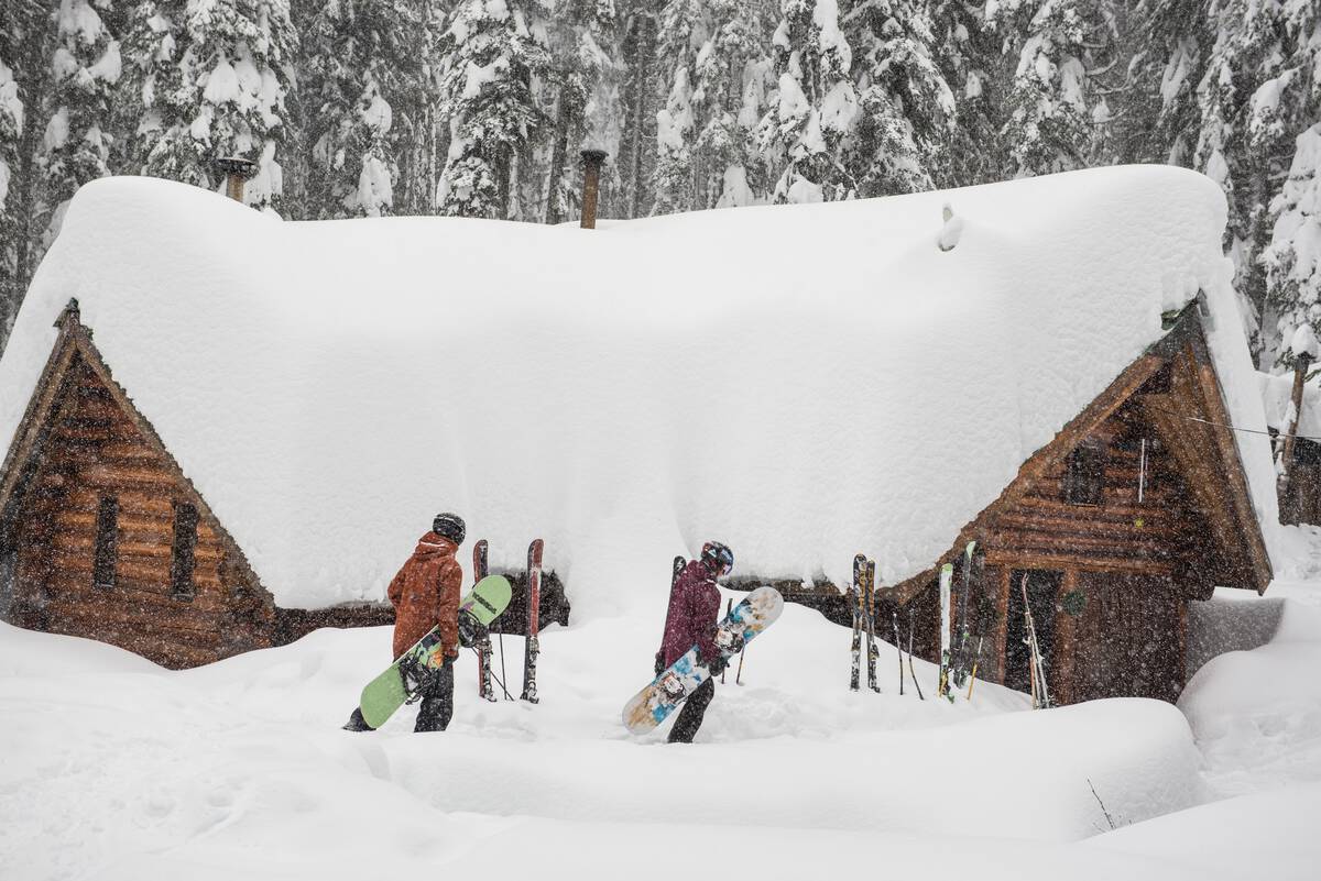Snowboarders heading to a private cabin at Red Mountain Resort.